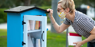 Woman looking into outside library shelf
