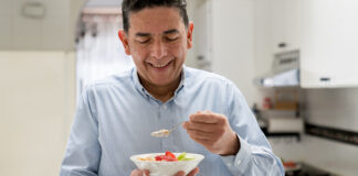 Man eating fruit from a bowl