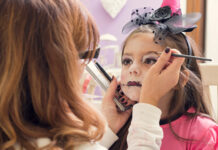 Mother applying make-up on daughter for Halloween