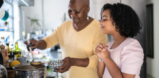 Woman with child cooking soup