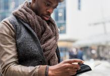 Man sitting outside reading a book