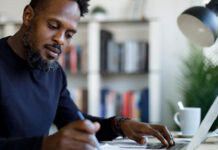 Man writing at desk.