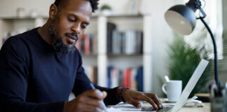 Man writing at desk.