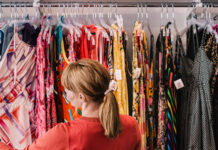 Woman looking through dresses on clothing rack