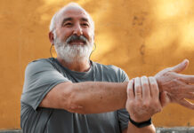 Grey-haired man stretching