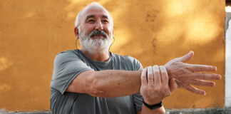 Grey-haired man stretching