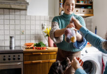 Man passing woman a bag of produce in the kitchen