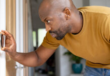 Man checking home thermostat