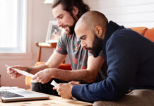 2 men reviewing paperwork at a computer