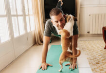 Man doing yoga with his dog