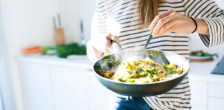 Woman holding a large bowl of pasta