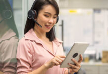 Une femme portant des écouteurs et regardant une tablette