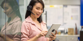 Une femme portant des écouteurs et regardant une tablette
